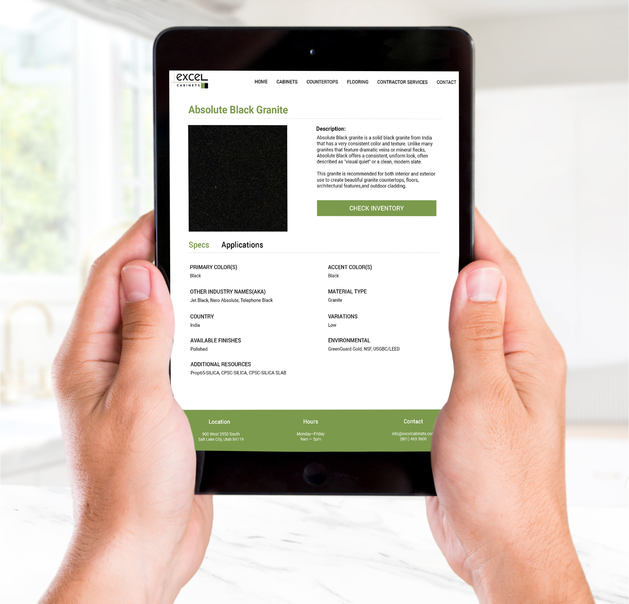 Hands holding a tablet displaying a product details page for Absolute Black Granite on the Excel Cabinets website, featuring product specifications, descriptions, and a check inventory button.